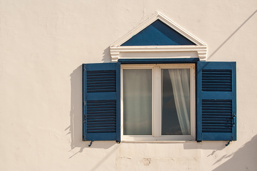 Abstract of Home Wall and Window with Shutters on the Island of Santorini Greece..