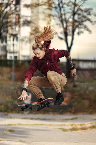 Young female skateboarder jumping