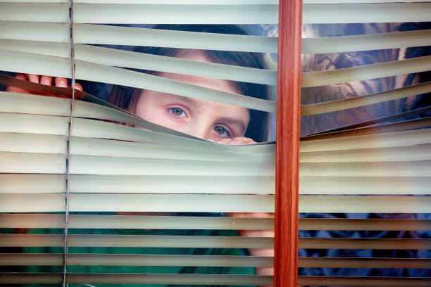 istock Child, toddler boy, looking through window 1253534851