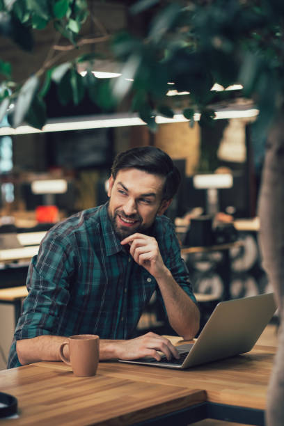 istock Positive office worker with modern gadget at the table alone 1253534852