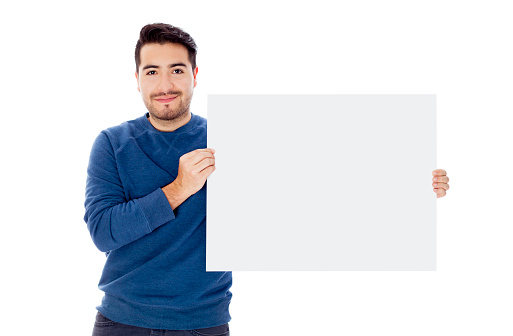 Handsome young man holding a white banner to edit while smiling at camera - Studio shot