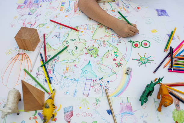 istock Boy drawing planet Earth and coronavirus motives 1253536833