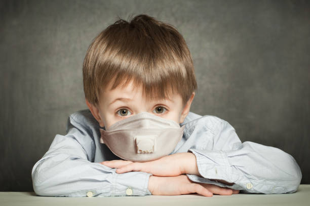 istock School kid in protective medical mask on blackboard background 1253537278