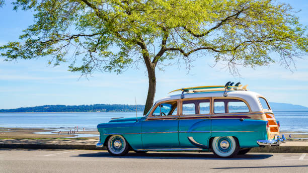 coche vintage aparcado en la playa tropical (costa) con tabla de surf en la azotea. viaje de ocio en verano. efecto de color retro. costa oeste océano pacífico. - taxi retro revival havana car fotografías e imágenes de stock