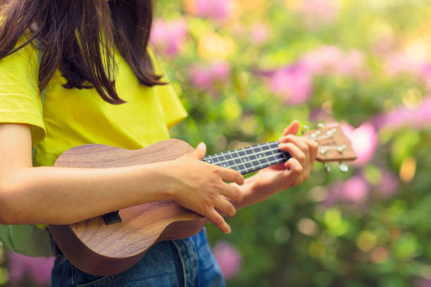 istock Girl practising ukulele outdoors 1253543296