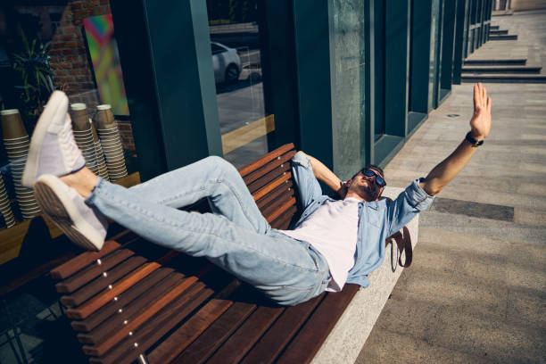 istock Relaxed young male person lying on the bench 1253546678