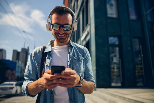 istock Joyful young man reading income message on telephone 1253546700
