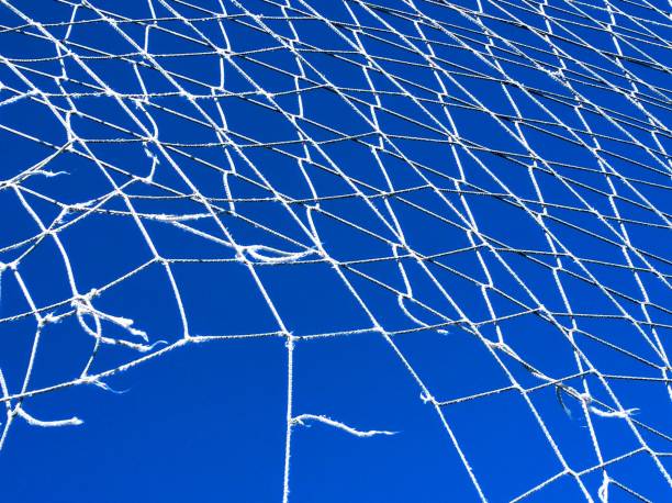 Broken net , clear blue sky, full frame. Broken tall safety net hanging, clear blue sky, full frame view suitable for background purposes. Galicia, Spain. safety net stock pictures, royalty-free photos & images