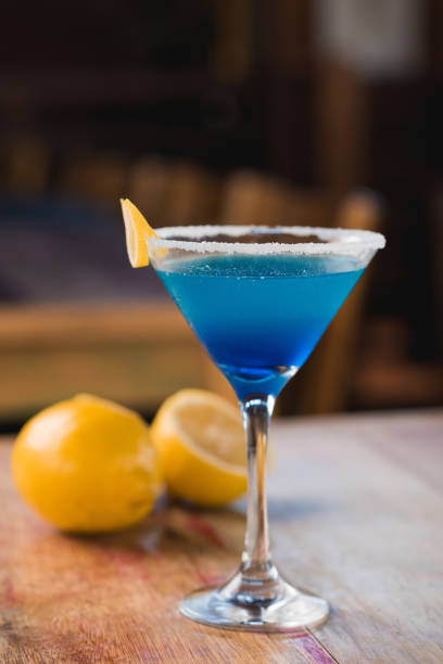 istock Blue margarita Cocktail drink, in front, with lemon in the background, on rustic table 1253548631