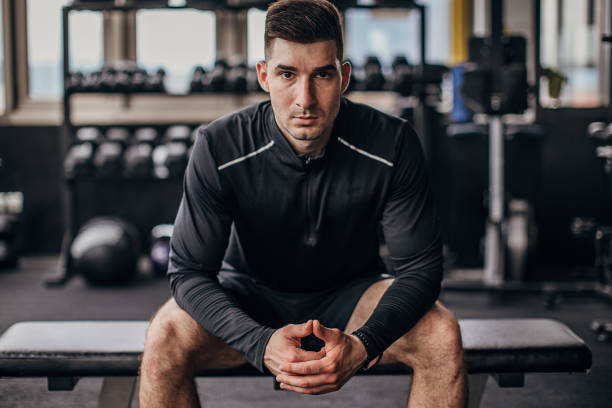 istock Fit man sitting in gym 1253548652