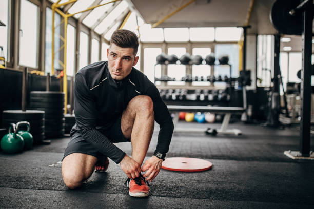 istock Fit man kneeling in gym 1253548699