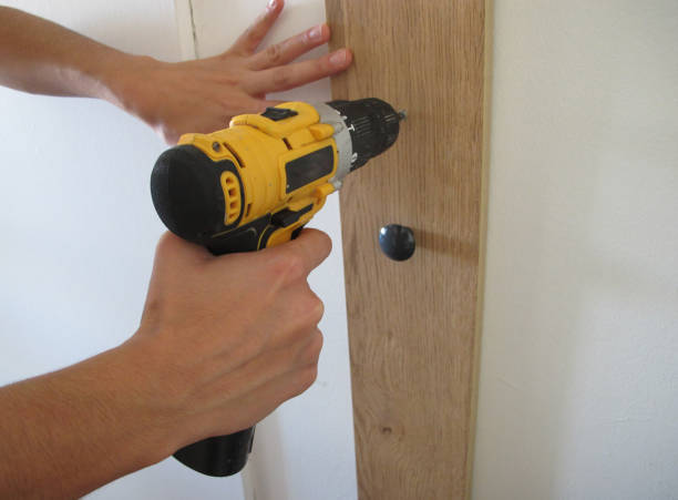istock Putting Up Wooden Shelf At Home Using Cordless Drill 1253548773