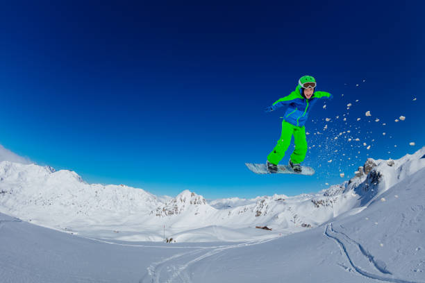 Female snowboarder making an awesome big jump of a kicker