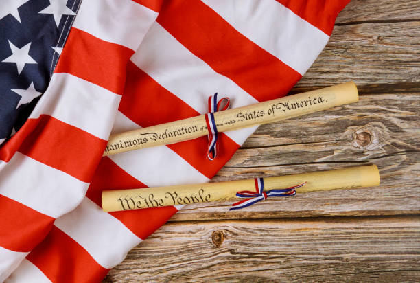 istock Fourth of July Day. Declaration of Independence parchment roll document with US flag. 1253565932