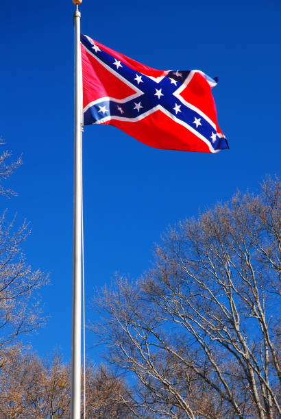 Confederate Battle flag The controversial Confederate battle flag flies over a Civil War Cemetery civil war photos stock pictures, royalty-free photos & images