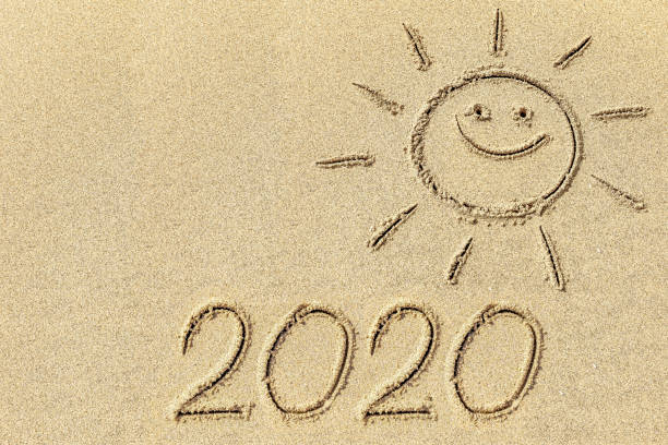 istock Drawing sun and 2020 on the sand 1253566713