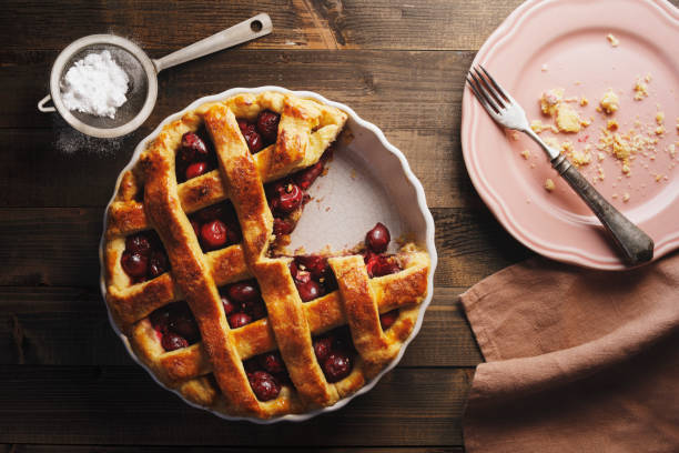 tarte aux cerises fraîchement cuite avec haut en treillis - saupoudreuse à farine photos et images de collection