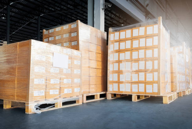 istock Stack of shipment package boxes wrapping plastic on pallets. Interior of warehouse storage, Warehouse industry delivery shipping goods, Logistics and transportation. 1253570514
