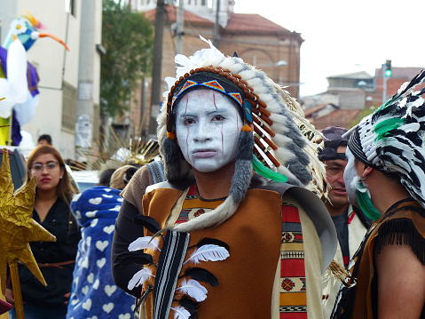 Cuenca, Ecuador - January 6, 2020: Traditional parade or masquerade on Day of the Innocents in Cuenca. Young man dressed as native american indian