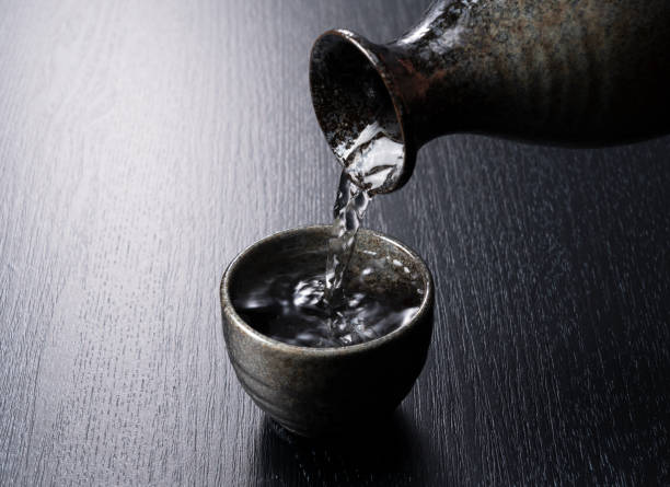 istock Pouring sake into a sake cup on a black background 1253575760