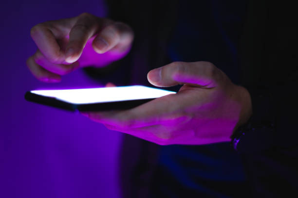 istock hand holds smartphone in the nightclub. 1253576084