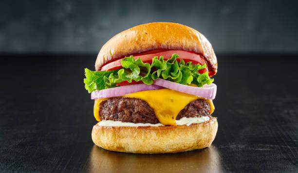 cheeseburger denso con formaggio americano, pomodoro lattuga e cipolla - pan brioche foto e immagini stock