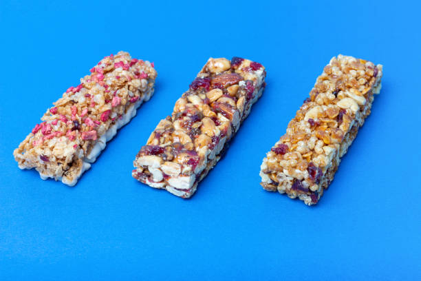 istock Three protein bars with cereals isolated on blue background 1253576881