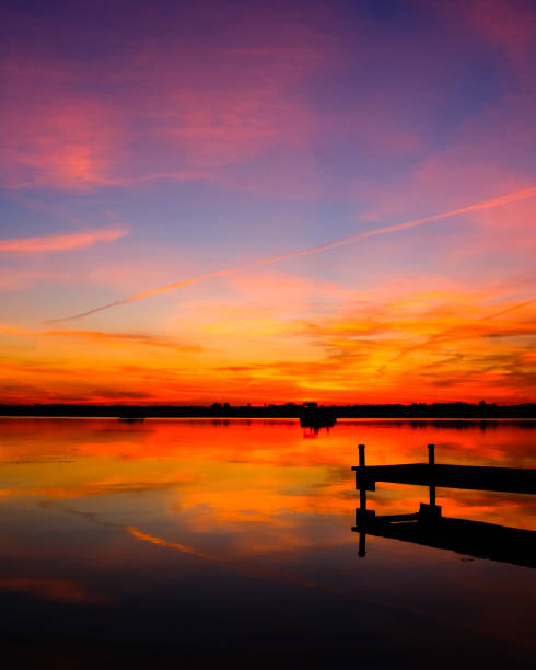 istock Beautiful lake sunset with a boat and pier 1253584569