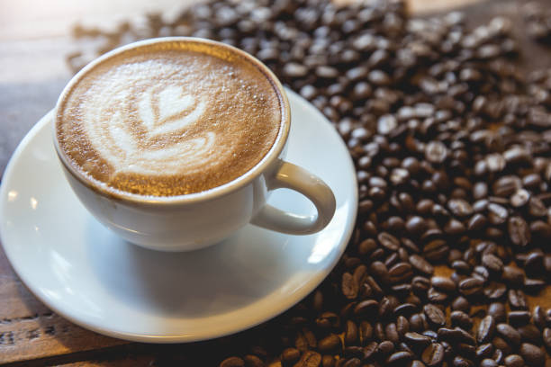 istock A cup of coffee with heart pattern in a white cup on wooden background 1253588680