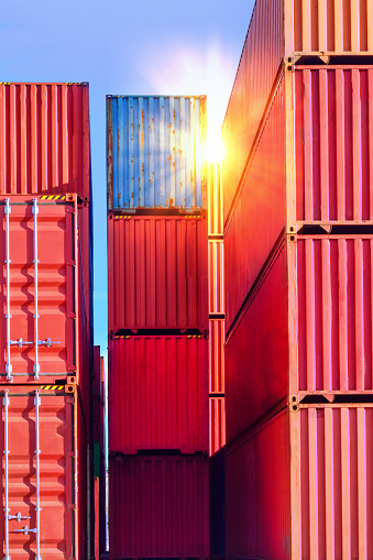 Containers stack inside container yardContainer handling. Container truck picking up container at yard. Port logistics, container yard operation. Container truck or Rubber Tired Gantry Cranes (RTG) picking up a container at yard. Port logistics, container yard operation.