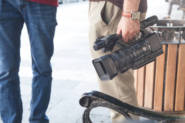 istock Video operator holding professional video camera in a city. 1253592028