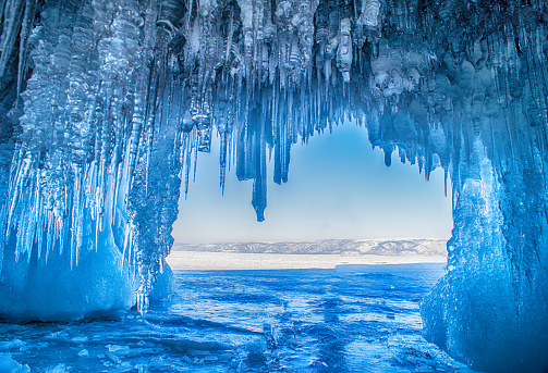 Baikal Lake in the winter cold day. Beautiful icy rocks with big ice crust.long icicles on the icy coastal cliffs of Olkhon Island