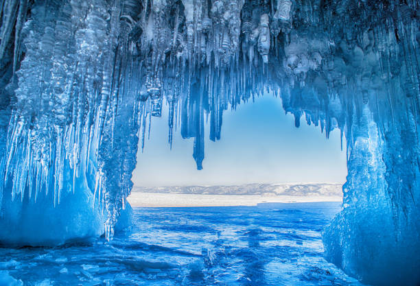 icicles on the icy coastal cliffs of Olkhon Island,Baikal Lake,Russia Baikal Lake in the winter cold day. Beautiful icy rocks with big ice crust.long icicles on the icy coastal cliffs of Olkhon Island icicle photos stock pictures, royalty-free photos & images