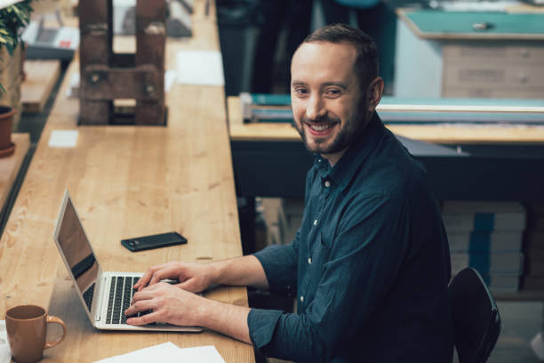 istock Happy young man during his pleasant working day in the office 1253596067