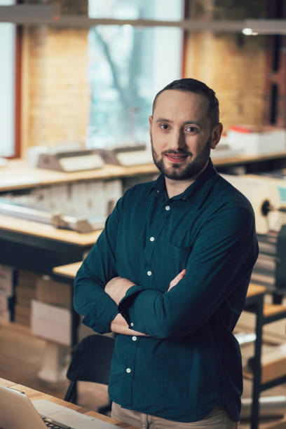 istock Attractive young man posing at his workplace and looking confident 1253596853