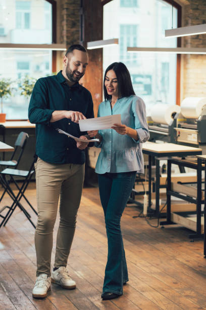 istock Friendly man helping his colleague with her project 1253597257
