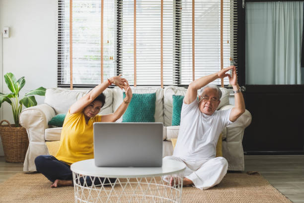 ejercicio asiático de entrenamiento para personas mayores y hacer yoga en casa - women yoga yoga class mature adult fotografías e imágenes de stock