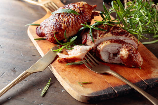 istock Smoked chicken  thighs with rosemary on a cutting board. 1253598292