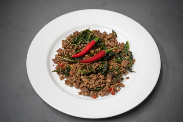 istock Thai Food stir-fried pork and basil on white plate. 1253599934