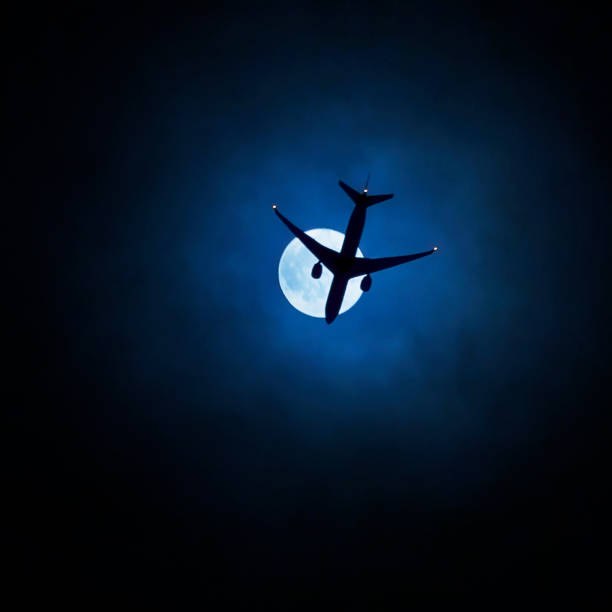 Airplane silhouette against moon Airplane silhouette against moon eclipse photos stock pictures, royalty-free photos & images