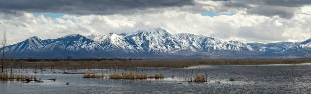 Loafer Mountain Panorama Beautiful view of snow covered Loafer Mountain with dramatic clouds in the sky, Utah Lake State Park, Provo Utah lake utah stock pictures, royalty-free photos & images