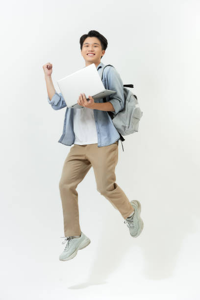 istock Jumping male Asian programmer with laptop on white background 1253601174