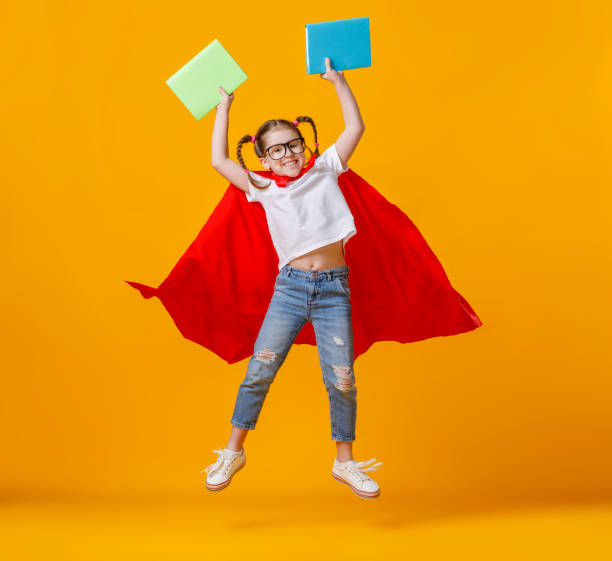 istock Little superhero jumping with notebooks 1253605777