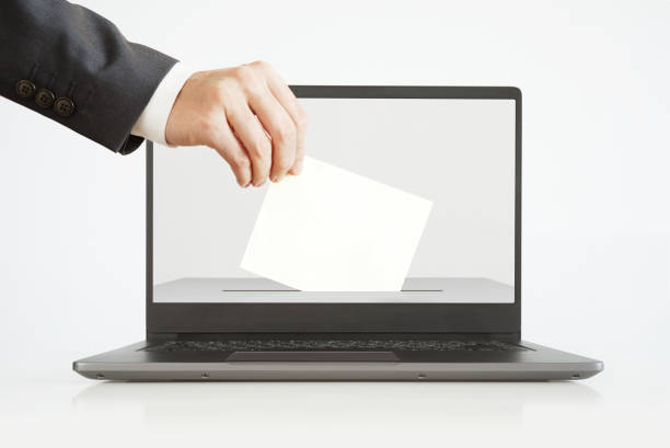 Voting Online Concept. Man Putting a Ballot into a Laptop.