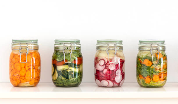 varias verduras fermentadas en tarros de albañil en el estante de la cocina - pickle relish fotografías e imágenes de stock