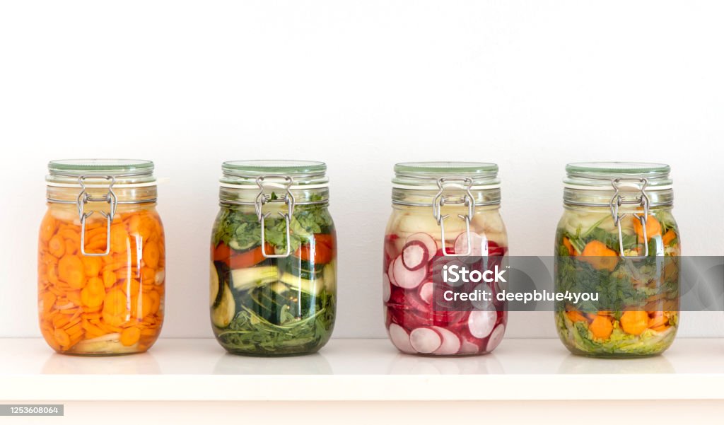 Various fermented vegetables in mason jars on the kitchen shelf Fermenting Stock Photo