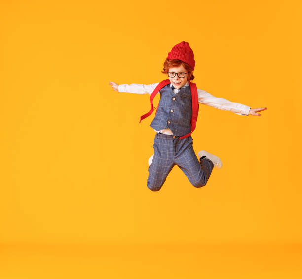 istock Energetic stylish schoolboy leaping up 1253608916
