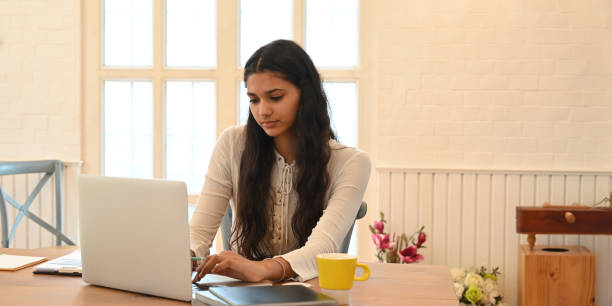 istock A university student is learning lessons online while sitting at the wooden working desk. 1253608950