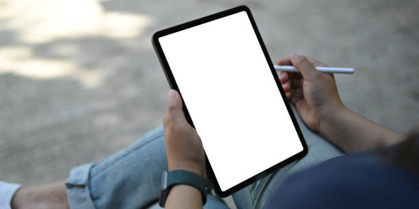 istock Woman holding white blank screen tablet and stylus pen at the workspace. 1253608957
