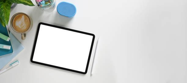 istock A white workspace is surrounding by a computer laptop, headphones, and accessories. 1253608995